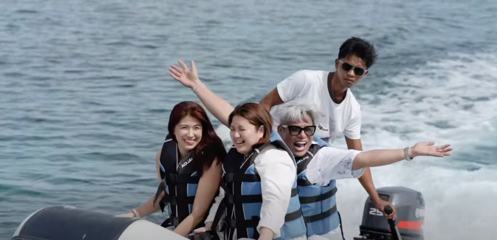 GCI members laughing and waving on a speedboat during island hopping in Talicud Island, Davao